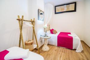 a small room with two beds and a table at A&S APARTAMENTOS MALAGA I in Málaga