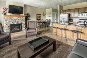 a living room with a fireplace and a kitchen at Bighorn Meadows Resort in Radium Hot Springs