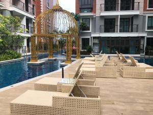 une rangée de bancs dans une piscine d'un bâtiment dans l'établissement Espana Condo Resort Pattaya EVT, à Jomtien Beach