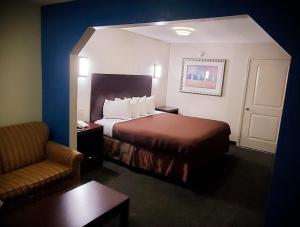 um quarto de hotel com uma cama e uma cadeira em Executive Inn em Pensacola