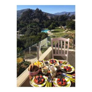 - une table avec des assiettes de nourriture sur le balcon dans l'établissement Entre Playa y Bosque Papudo, à Papudo