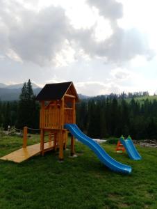 un parque infantil con tobogán y una casa de juegos en Cichy Domek, en Małe Ciche