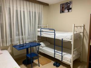 1 dormitorio con 2 literas y mesa azul en Hayat pansiyon, en Estambul