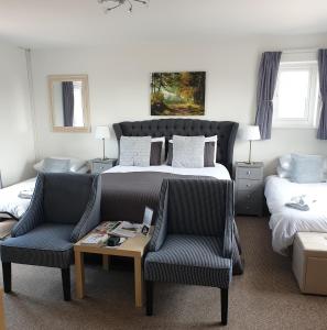 a bedroom with a bed and two chairs and a table at The Moorhead Bed & Breakfast in Wem