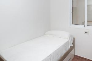 a white bed in a room with a mirror at ROS MARY, 7º-14 in Cullera