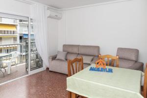 a living room with a table and a couch at ROS MARY, 7º-14 in Cullera