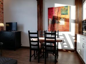 a dining room table with chairs and a painting on the wall at Apartamenty Bydgostia in Bydgoszcz