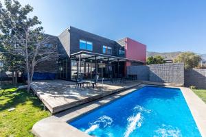 a house with a swimming pool in front of a house at Hotel Piedra Verde in Rancagua