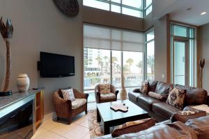 a living room with a couch and a tv at Sapphire Bungalow #106 in South Padre Island