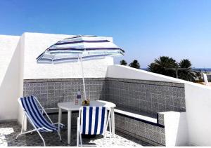 stół i dwa krzesła z parasolem w obiekcie City Apartment sur le port de Mahdia Free Wifi w mieście Mahdia