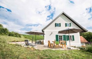 a house with two umbrellas and a table and chairs at Schwalbennest Pongratz in Gamlitz