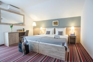 a hotel room with a large bed and a desk at GuestHouse Jagic in Plitvička Jezera