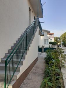 a stairway with a green railing next to a building at Apartment Računica in Vodice