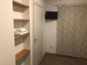 a bathroom with a closet with a door and towels at Ibisco Affittacamere in Iesi