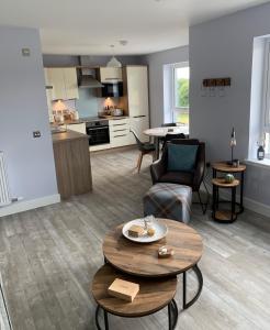 a living room with two tables and a kitchen at 23 C Allan Gardens in Dornoch