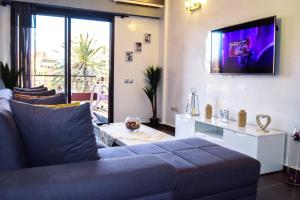 een woonkamer met een bank en een tv aan de muur bij Apartment in Marrakesh, Gueliz in Marrakesh