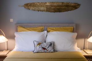 ein Bett mit zwei Kissen und einem Kopfteil in der Unterkunft POP'S APPARTEMENTS RESIDENCE MARISOL au bord de la mer in Le Gosier + 23 Fotos
