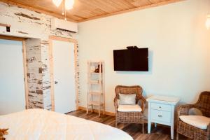 a bedroom with a bed and a tv on a wall at Deer Run on the Atlantic in Big Pine Key