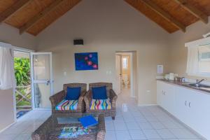 a living room with two chairs and a kitchen at Manea on Muri in Rarotonga