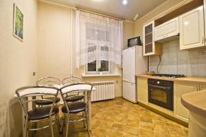 モスクワにあるLakshmi Apartment 3k Mayakovskayaのキッチン(テーブル、椅子、白い冷蔵庫付)