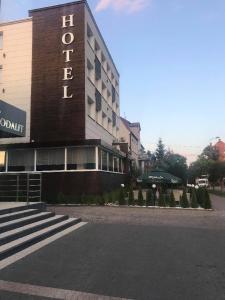 Hotel Tiffany في نوفي مياستو لوبافسكي: مبنى الفندق مع وجود سيارة متوقفة أمامه