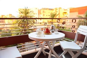 een witte tafel en 2 stoelen op een balkon bij Apartment in Marrakesh, Gueliz in Marrakesh