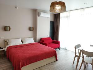 a bedroom with a red bed and a red chair at Green Line in Mtsvane Kontskhi