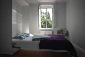 łóżko w pokoju z oknem w obiekcie Apartament Terra Pia w Poznaniu