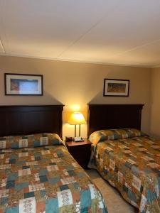 a hotel room with two beds and a lamp at Inn on the Gulf in Hudson