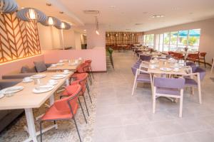 a restaurant with wooden tables and chairs and windows at Verdanza Hotel in San Juan