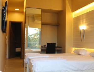 蘇達的住宿－Oneiro Suites，一间卧室配有两张床和镜子