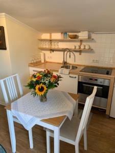 una cocina con una mesa con un jarrón de flores. en Ferienwohnung Giacomelli 3, en Rottach-Egern