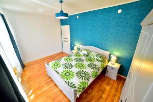 a bedroom with a white bed and a blue wall at Old City Apartment in Sibiu