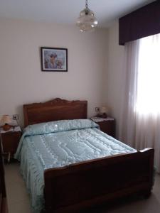 sypialnia z łóżkiem z niebieską kołdrą w obiekcie Se alquila piso en Sanxenxo con vistas al mar w mieście Sanxenxo