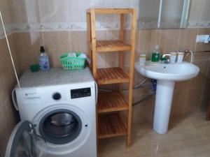 W łazience znajduje się pralka i umywalka. w obiekcie Se alquila piso en Sanxenxo con vistas al mar w mieście Sanxenxo
