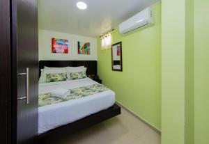 a bedroom with a blue wall and a white bed at Hotel Marina Suites By GH Suites in Cartagena de Indias