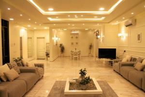 a large living room with couches and a table at Marbel Chalet in Buraydah