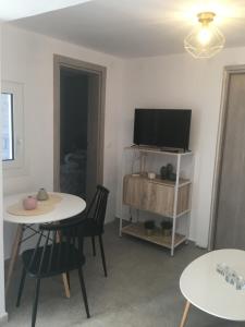 Villakia Katerina في ليبسوي: غرفة معيشة مع طاولتين وتلفزيون بشاشة مسطحة