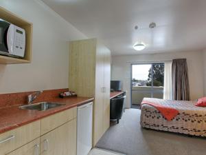 a hotel room with a tv and a sink at Bella Vista Hokitika in Hokitika