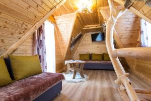Cabaña de madera con sala de estar con sofá y mesa en domek góralski, en Zakopane