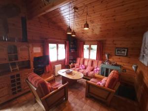 una sala de estar con sofás y una mesa en una cabaña en Chalet Kylucru 6 personnes classé 2 étoiles en Xonrupt-Longemer