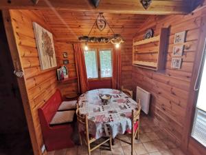 een eetkamer in een blokhut met een tafel en stoelen bij Chalet Kylucru 6 personnes classé 2 étoiles in Xonrupt-Longemer