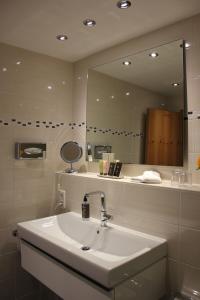 a bathroom with a sink and a mirror at Hotel Ratsstuben in Lindau +75 photos
