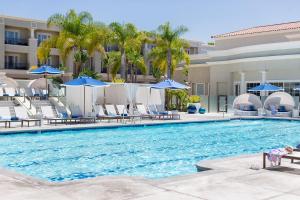 uma piscina num resort com cadeiras e guarda-sóis em Balboa Bay Resort em Newport Beach
