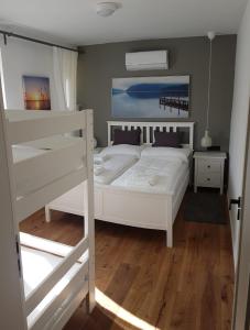 1 Schlafzimmer mit einem weißen Bett und 2 Etagenbetten in der Unterkunft Storchennest-Appartements in Rust