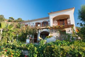 a large white house with a balcony on a hill at Niriides Studios in Armenistis