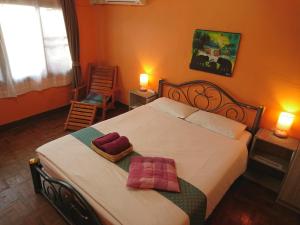una camera con un letto con due cuscini sopra di Meechok Home a Chiang Mai