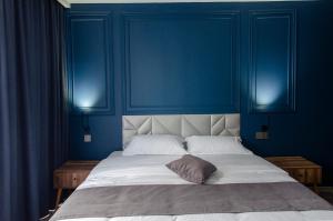 Dormitorio azul con cama con almohada en The Residence Hotel & Cottages, en Kojori