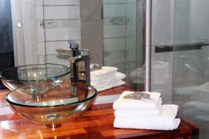 W łazience znajduje się szklana umywalka i ręczniki. w obiekcie Burdigala Homes - Appart Montesquieu w mieście Bordeaux