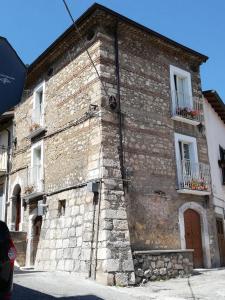 ein altes Backsteingebäude mit zwei Fenstern und einer Tür in der Unterkunft Le dimore del Mercante in Luco neʼ Marsi